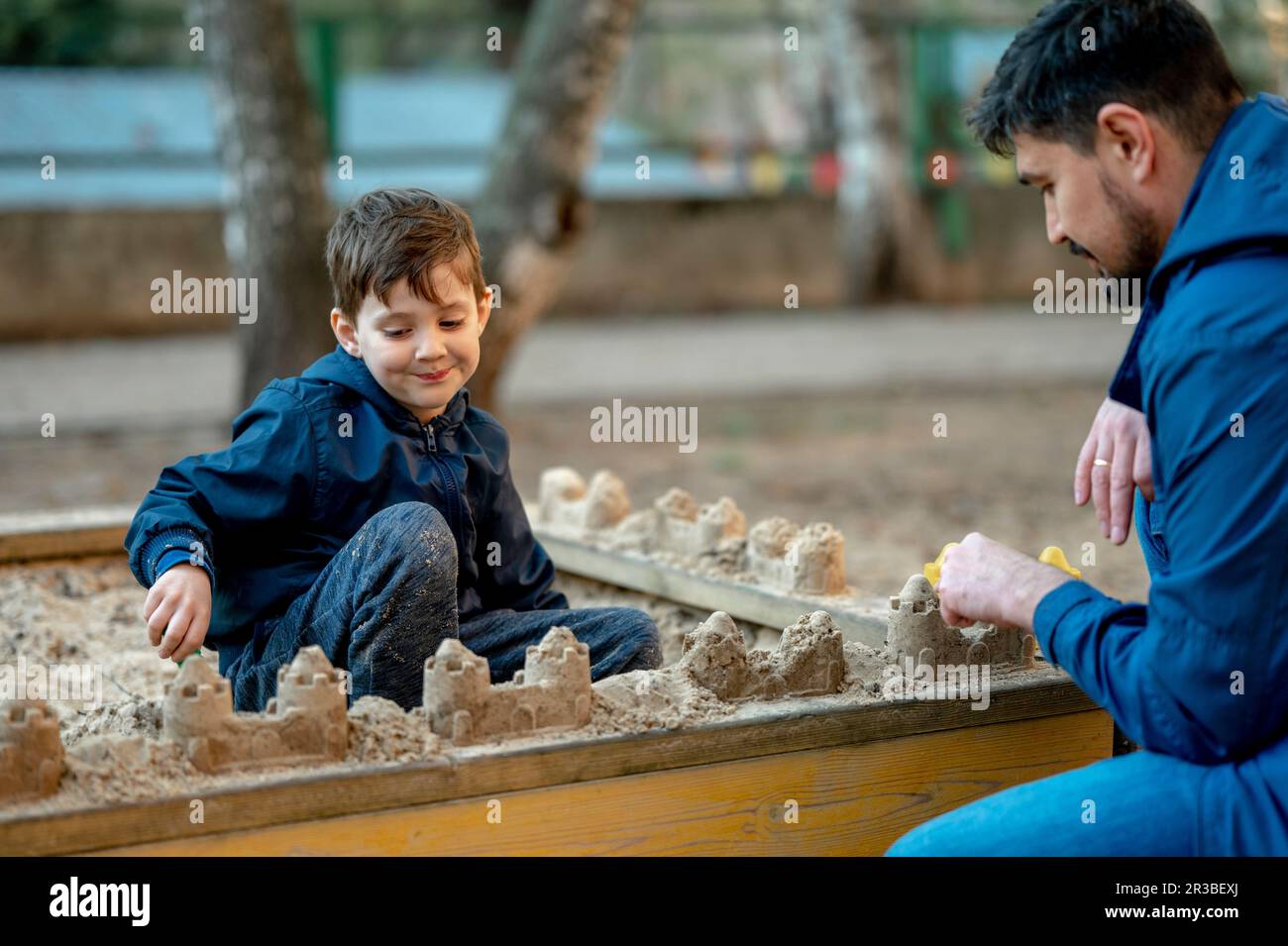 Vater und Sohn bauen Sandburgen auf Sandkästen im Park Stockfoto