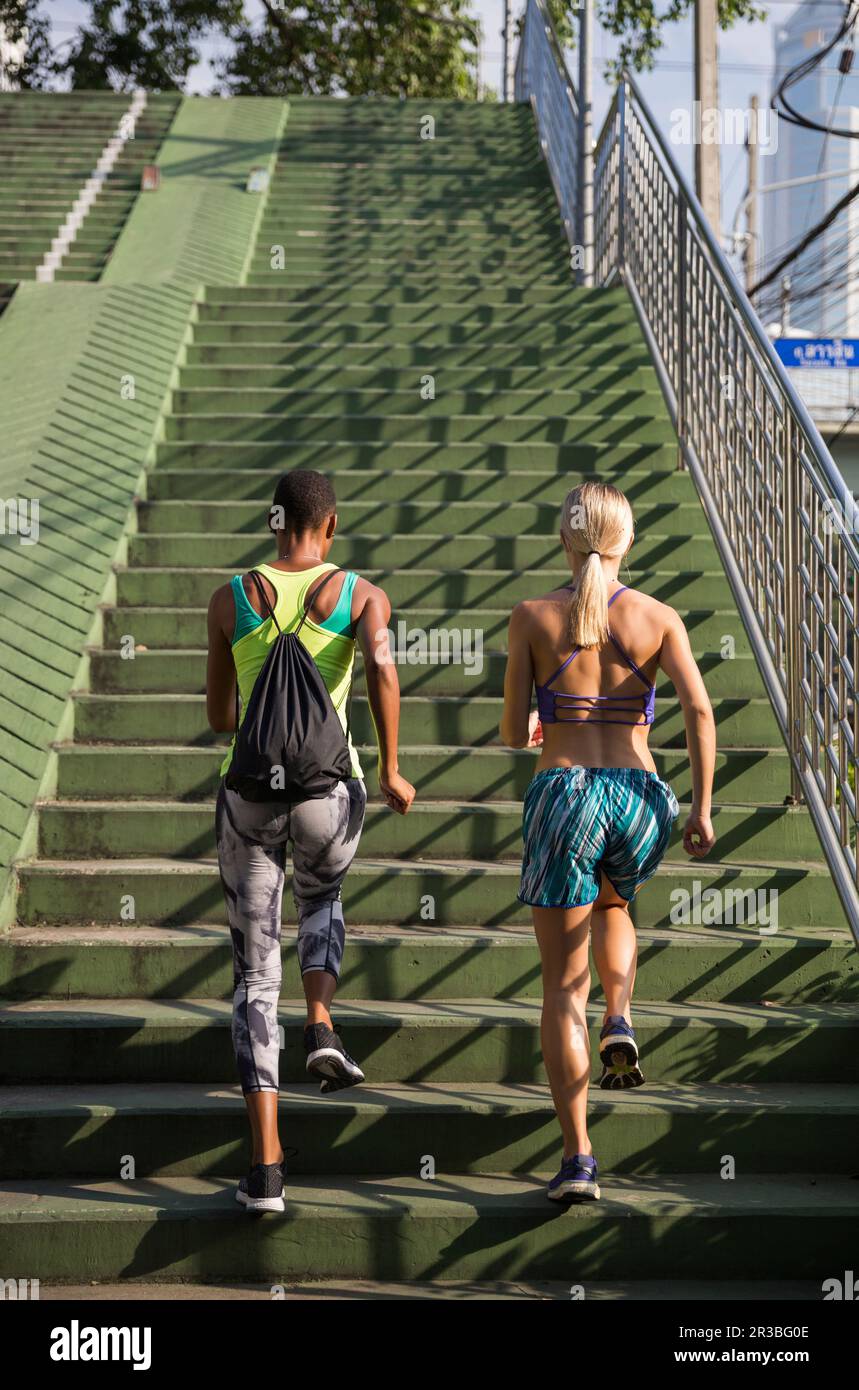 Multirassische Frauen, die an sonnigen Tagen auf Treppen trainieren Stockfoto