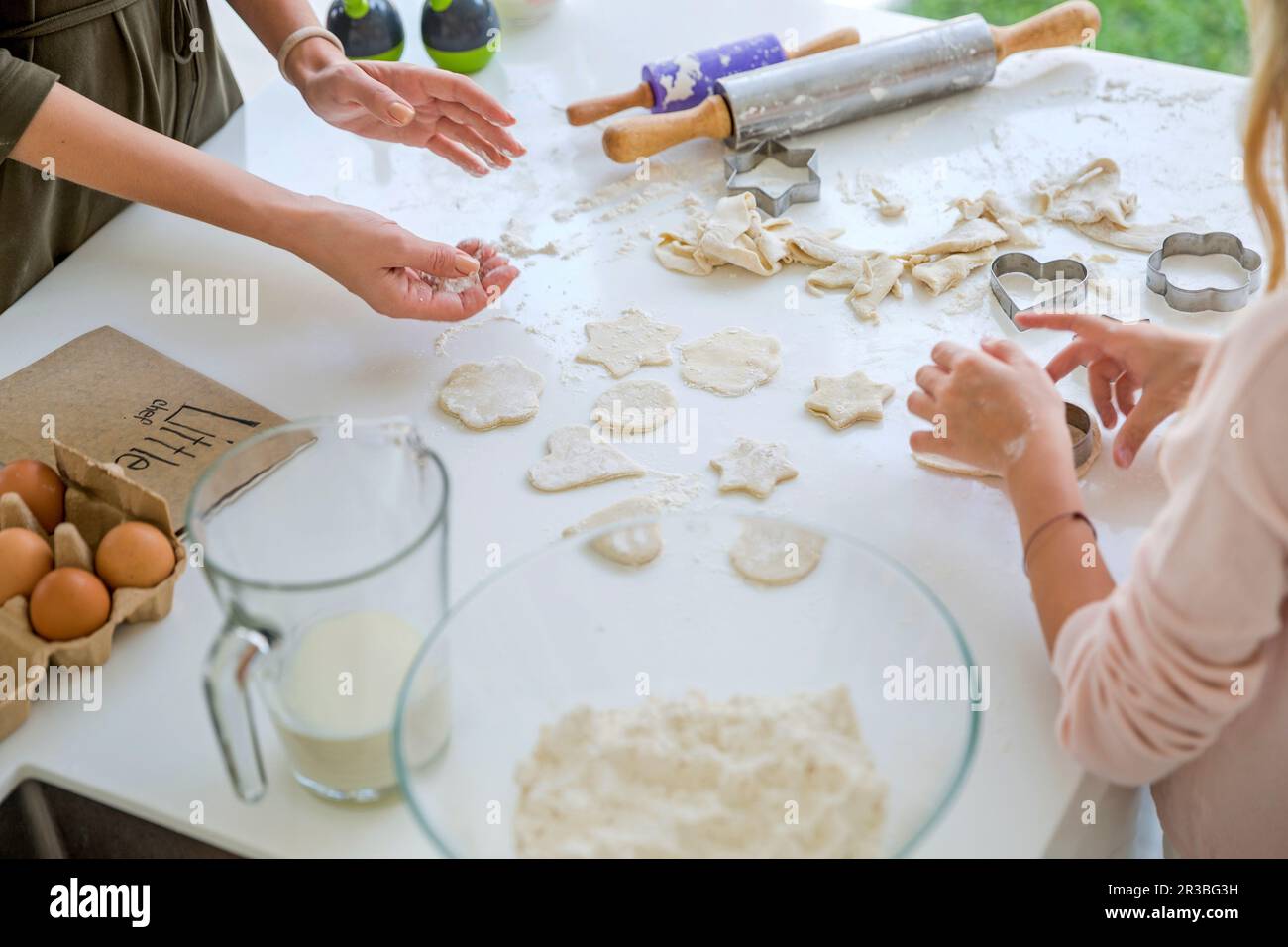Mutter und Tochter, die zu Hause in der Küche andere Formen als Teig herstellen Stockfoto