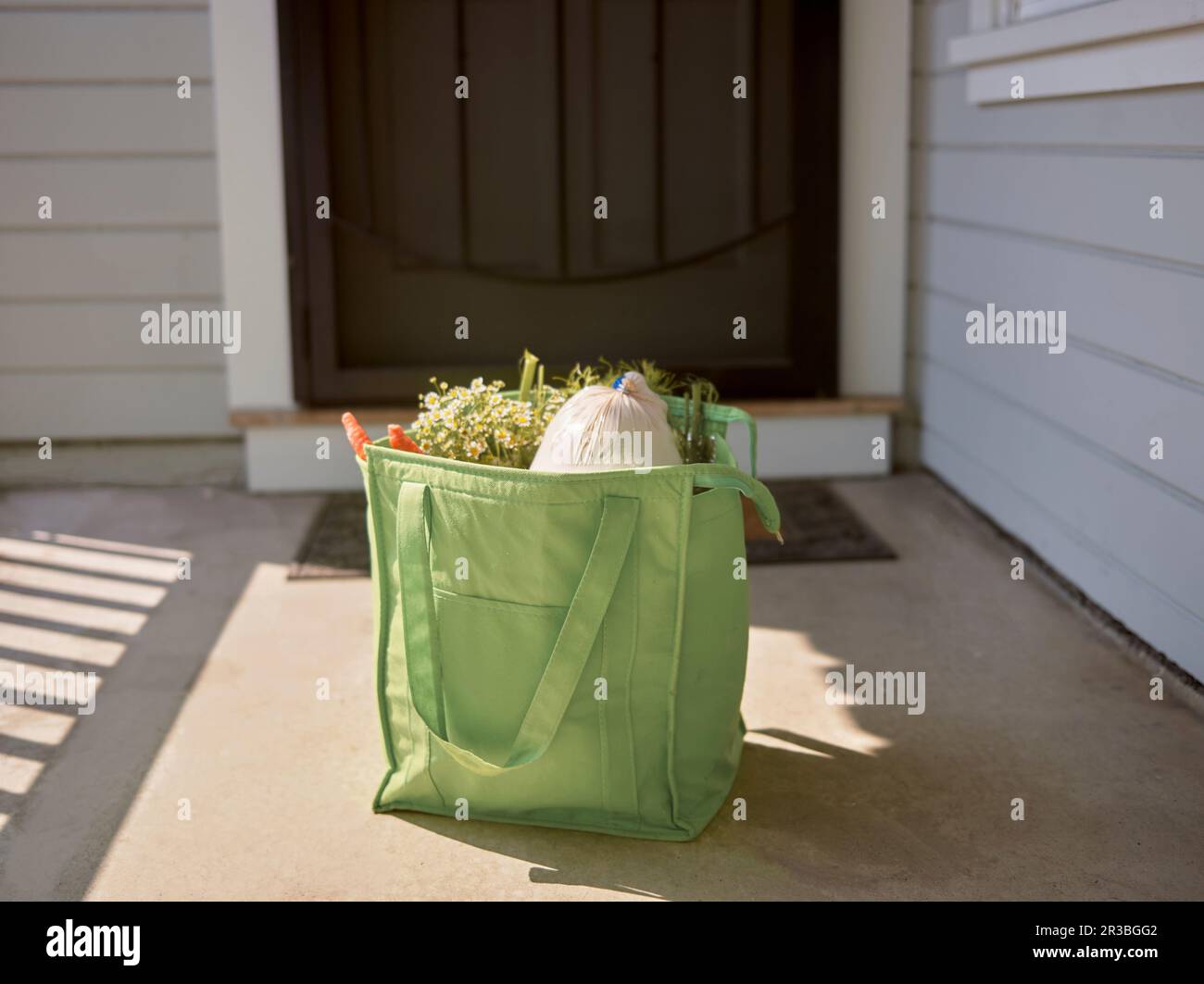 Online-Lebensmitteleinkäufe in einer Tasche vor der Haustür Stockfoto