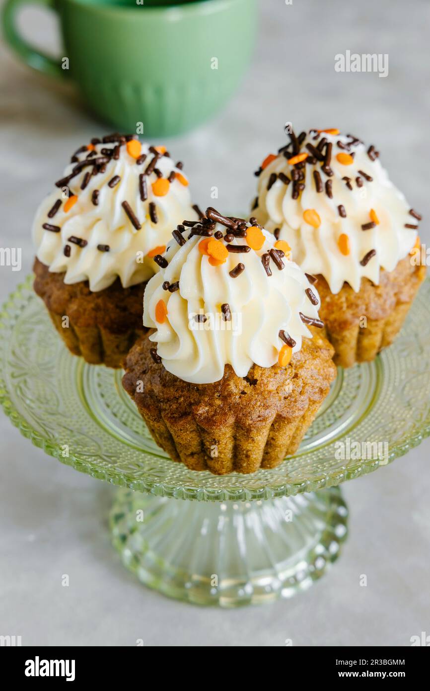 Herbstcupcakes mit gewürzten Karotten und Nüssen, dekoriert mit Frischkäse-Glasur und Streuseln Stockfoto