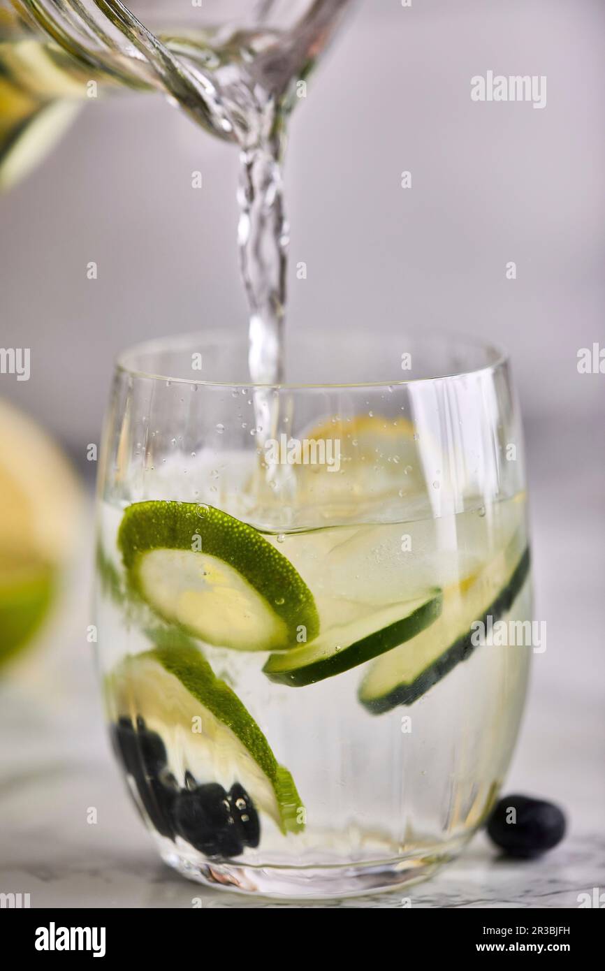 Füllen Sie frisches, kaltes Wasser in ein Glas Stockfoto