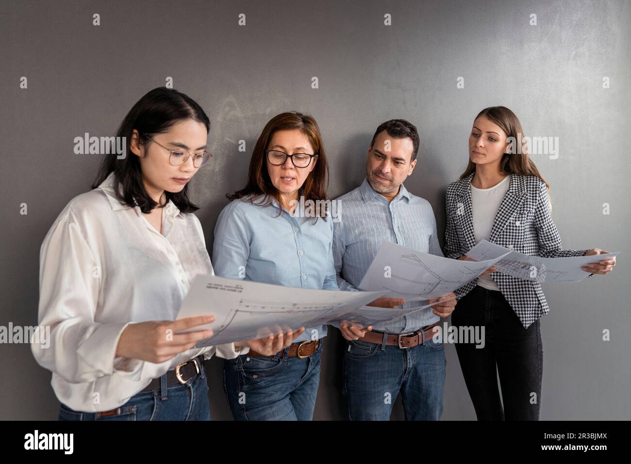 Geschäftsleute stehen an einer Wand und arbeiten an einem Architekturprojekt Stockfoto
