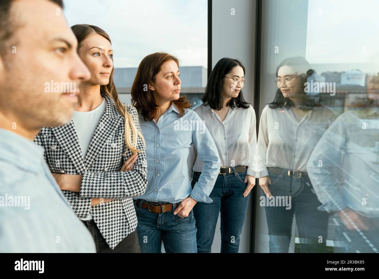 Aufmerksames Business-Team, das im Büro aus dem Fenster blickt Stockfoto