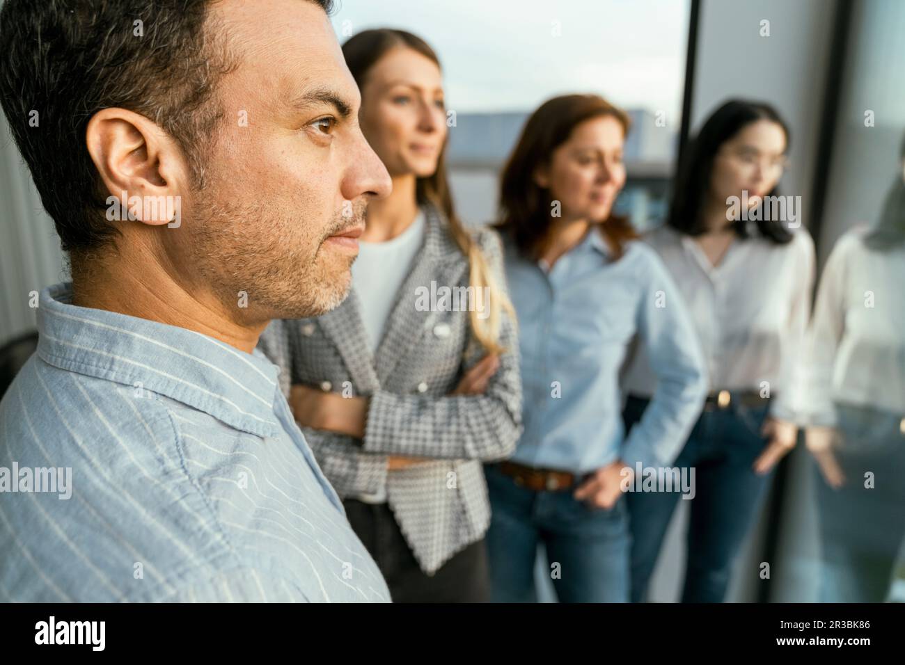 Aufmerksames Business-Team, das im Büro aus dem Fenster blickt Stockfoto