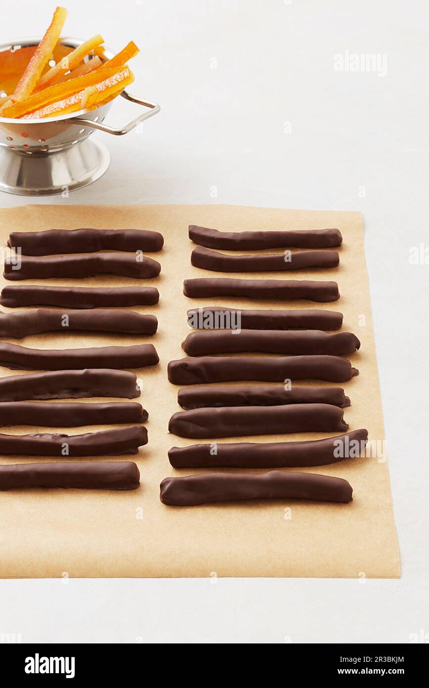 Mit Schokolade überzogene Orangenstäbchen hintereinander Stockfoto