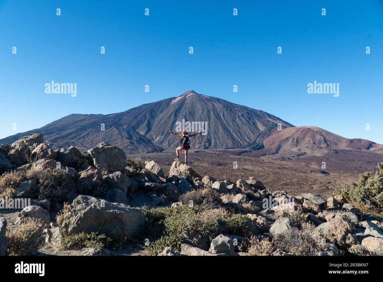 Frau mit Rucksackwanderung mit malerischem Blick auf den Sonnenaufgang am Morgen auf die einzigartige Felsformation Roque Cinchado, Roques de Garcia, Teneriffa, Kanarische Inseln Stockfoto