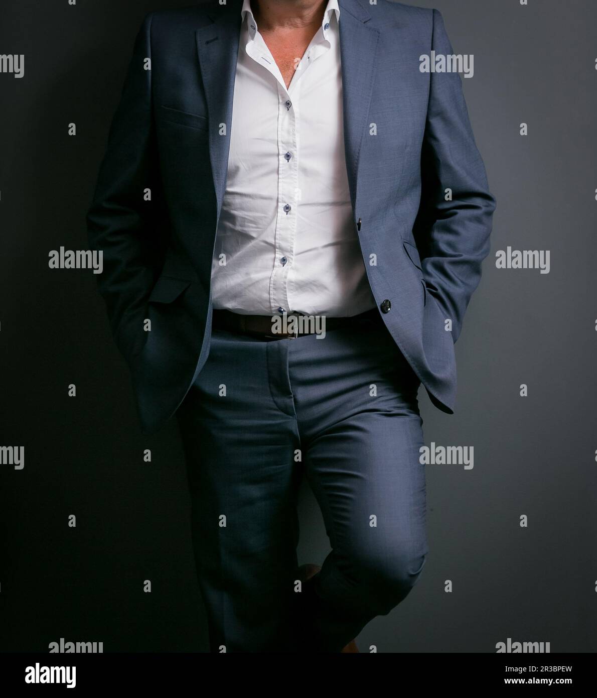 Verkürzter Mann im eleganten Anzug mit Händen in Taschen Stockfoto