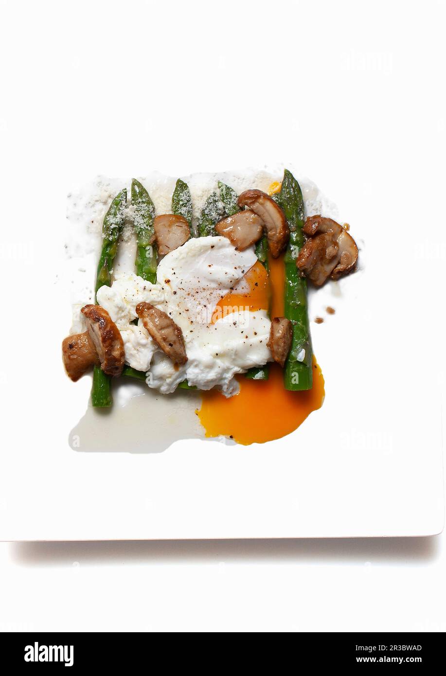 Grüner Spargel mit pochiertem Ei und Pilzen Stockfoto