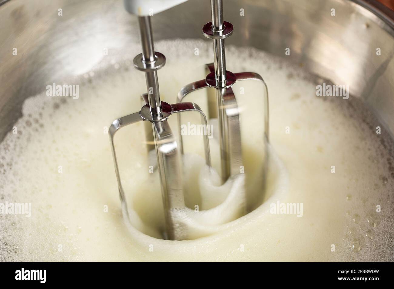 Eiweiß mit einem Handmixer verprügeln, bis es steif ist Stockfoto