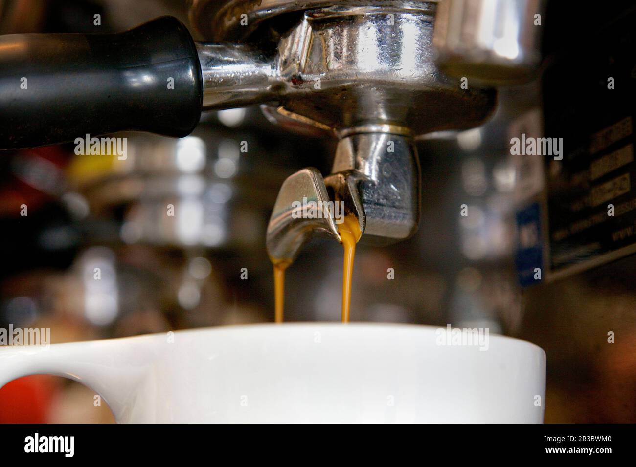 Nahaufnahme des doppelten Espressos, der in den Becher tropft Stockfoto