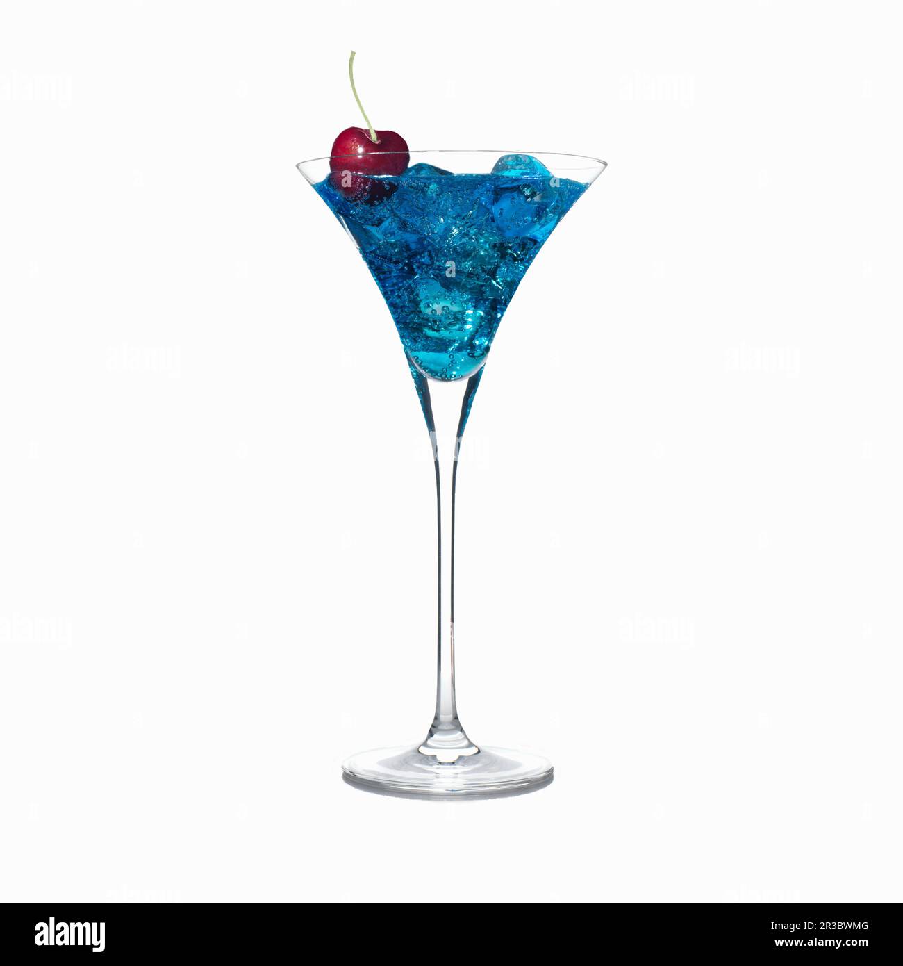 Blauer Cocktail in martini-Glas mit Eiswürfeln und einer Kirschgarnierung Stockfoto