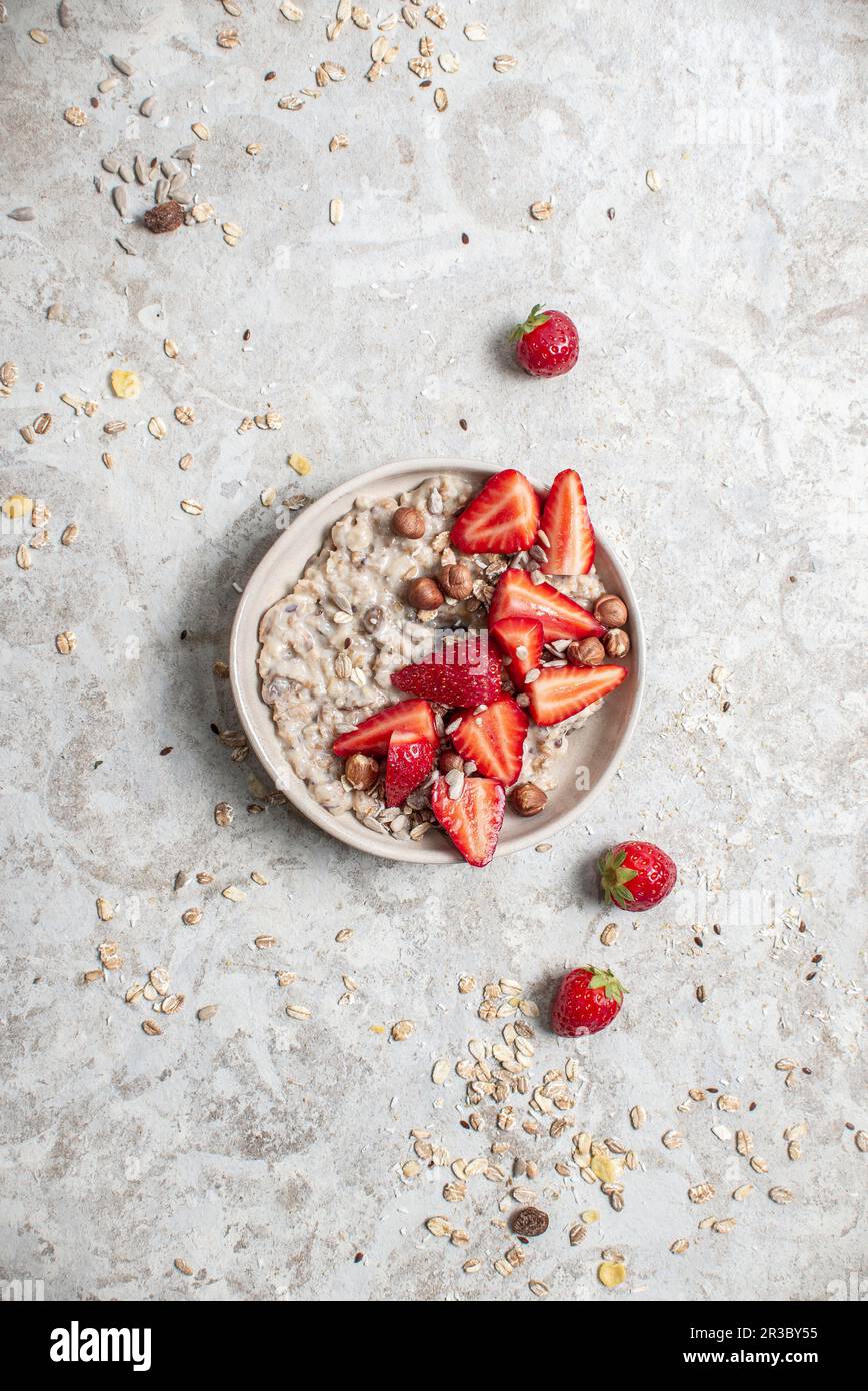 Haferflocken mit Erdbeeren und Haselnüssen Stockfoto