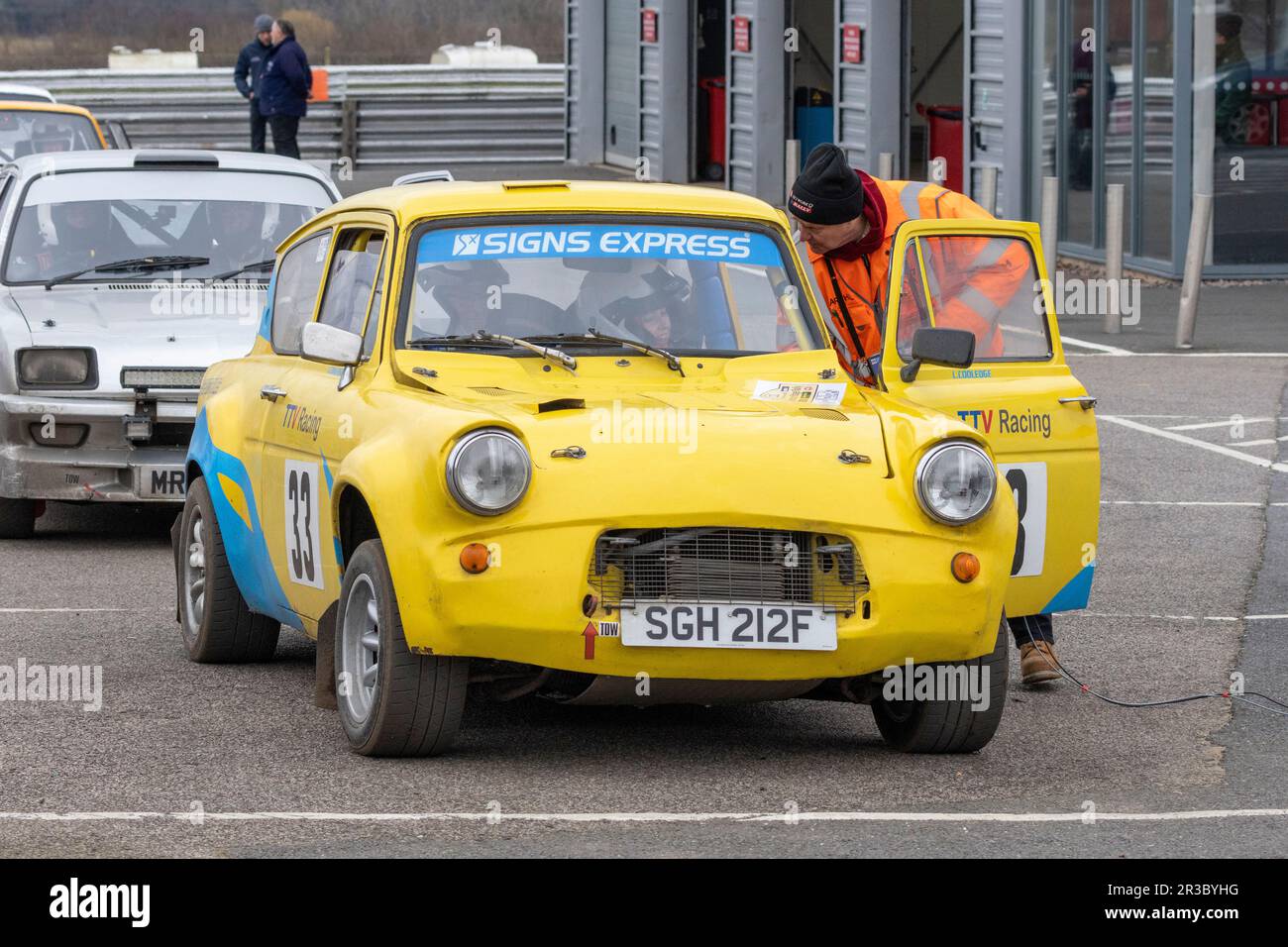 John Cooledge in seinem 1967 Ford Anglia 105E mit dem Control Point Marshal während der Snetterton Stage Rally 2023, Norfolk, Großbritannien. Stockfoto