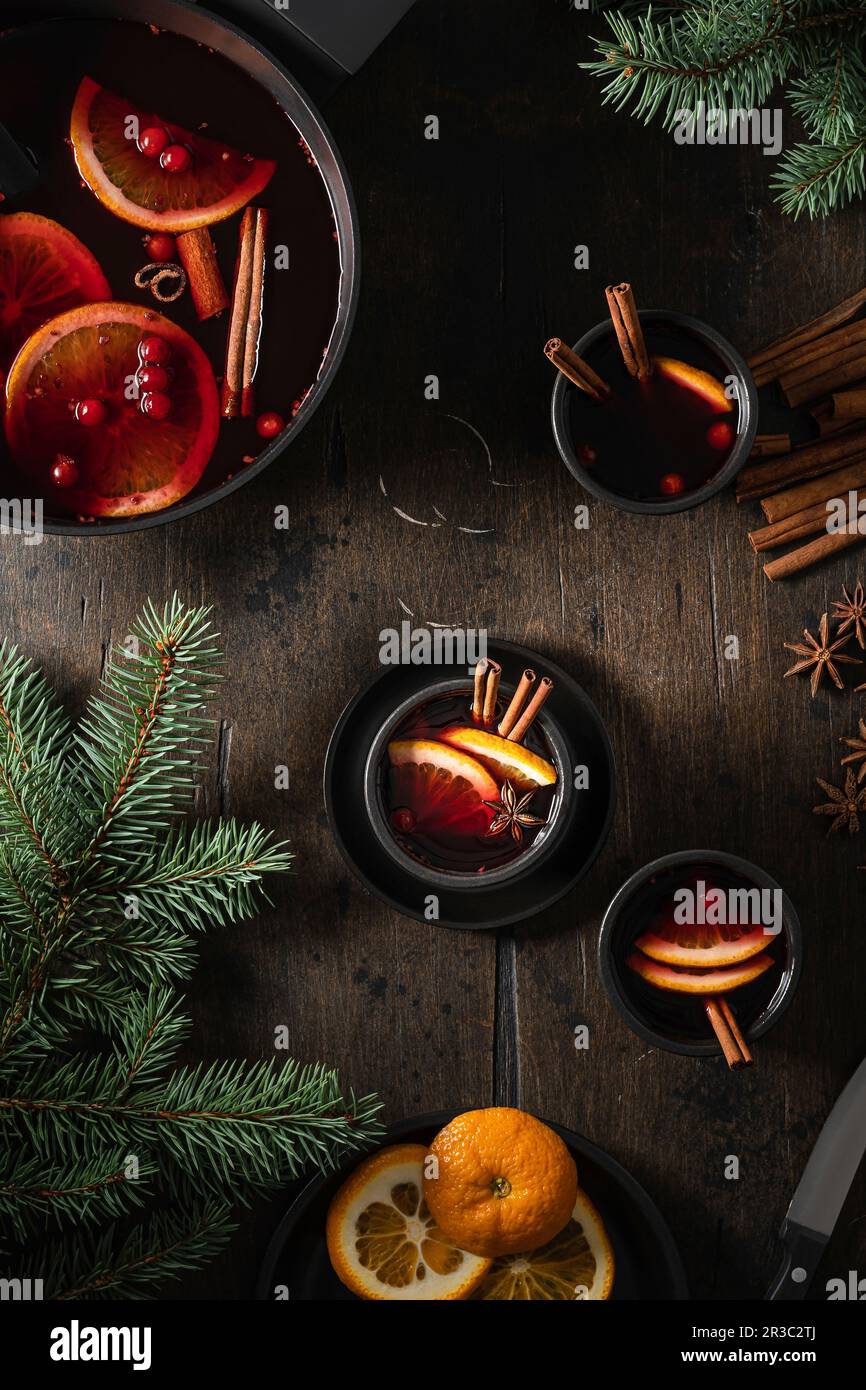 Glühwein in Bechern mit Orangenscheiben auf einem Holztisch Stockfoto