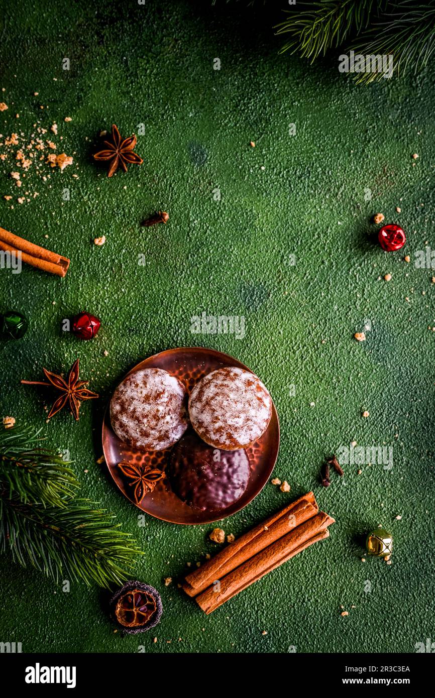 Lebkuchen, Weihnachtsgewürze und Tannenzweige auf grünem Hintergrund Stockfoto