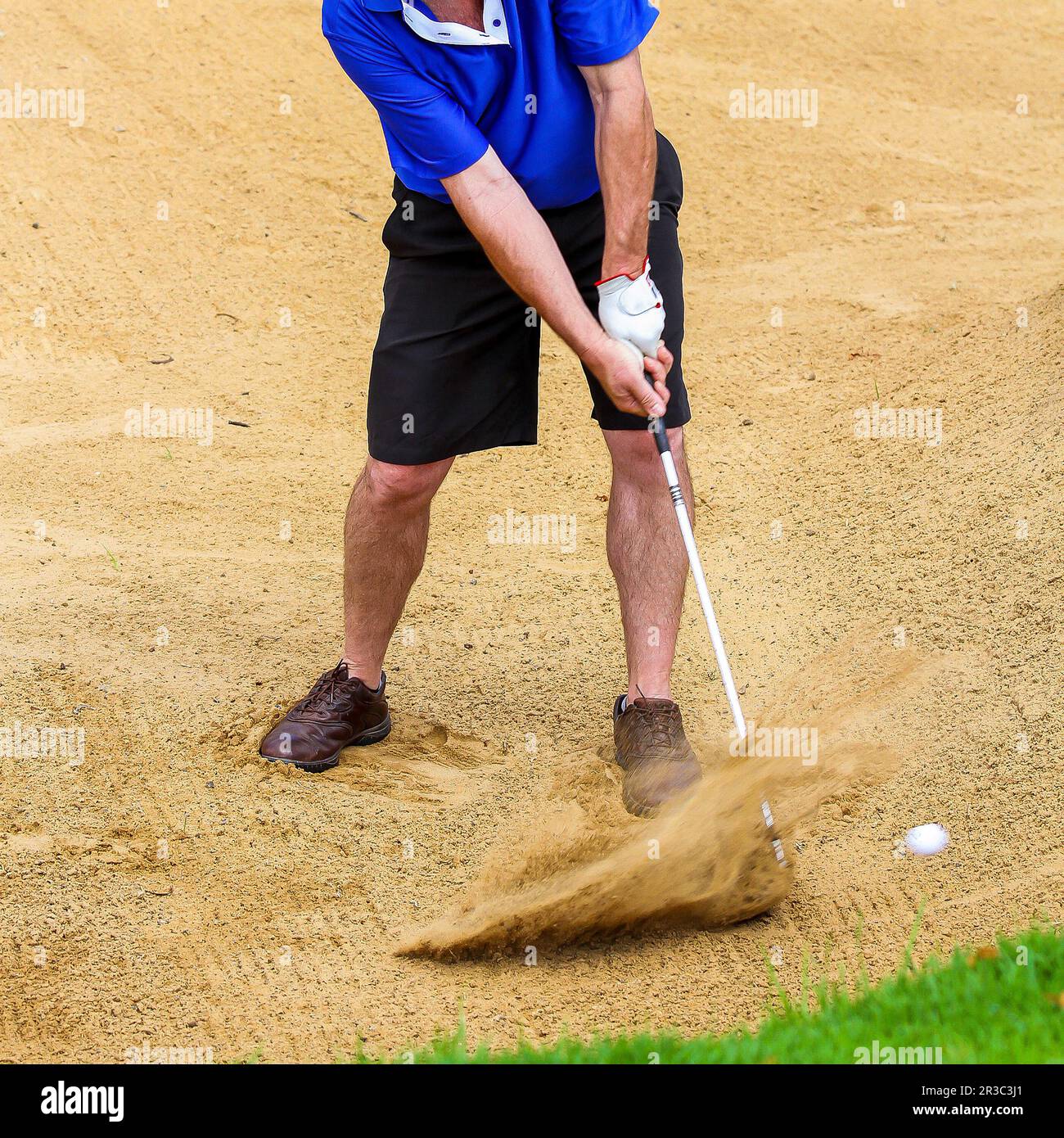 Ein Mann, der einen Golfball aus einem Bunker schlägt Stockfoto