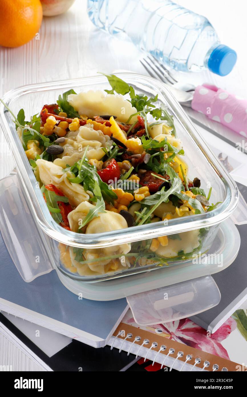 Lunchbox mit Salat mit Fleisch-Tortellini und Gemüse Stockfoto