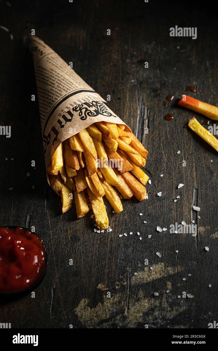 Pommes Frites in einer Papiertüte mit Salz und Ketchup Stockfoto