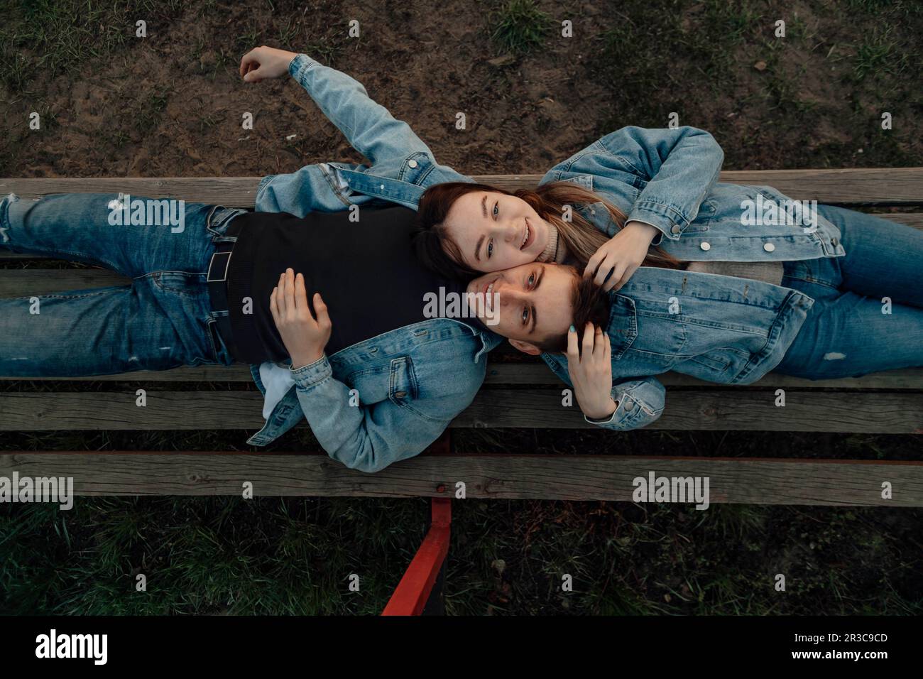 Glückliches junges, liebevolles Paar, das sich auf der Bank im Park entspannt Stockfoto