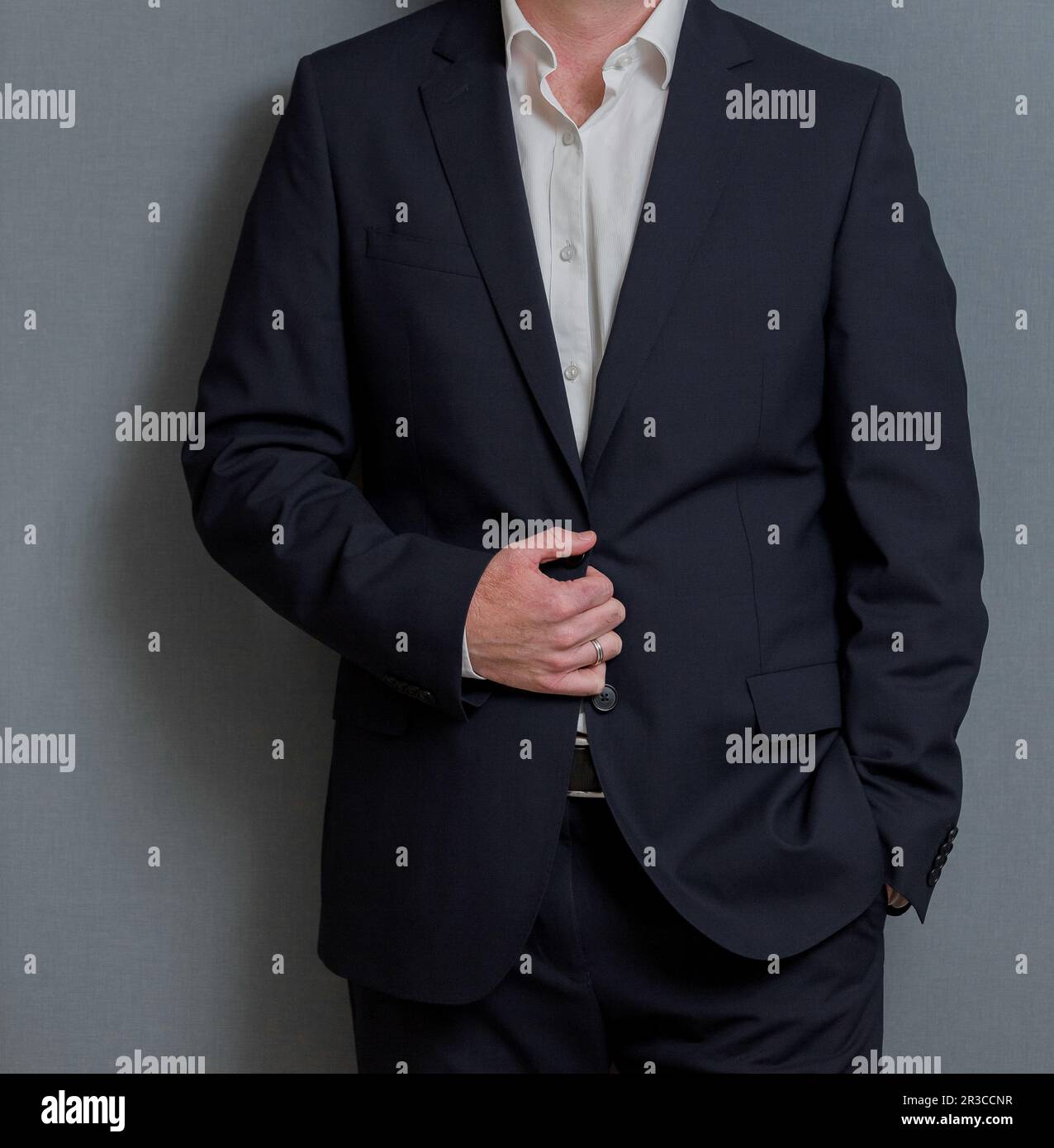 Verkürzter Mann im eleganten Anzug mit Händen in Taschen Stockfoto