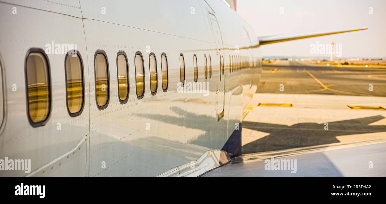Flugzeugfenster eines Jumbo-Jet, der auf der Rollbahn eines Flughafens geparkt ist Stockfoto