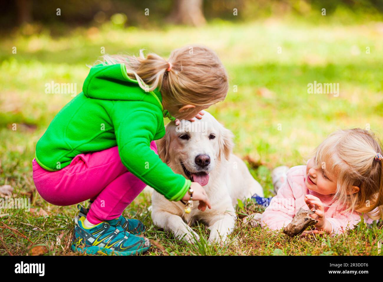 Zwei Mädchen verbringen Zeit mit ihrem gehorsamen Hund Stockfoto