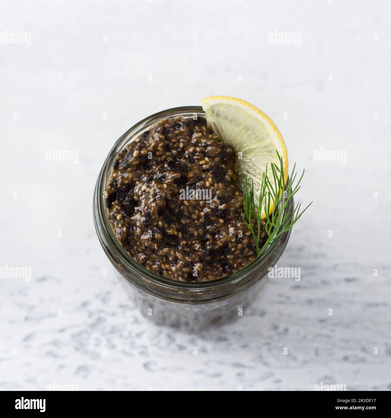 Vegan gesunder Chia-Kaviar mit Nori und Sojasoße in einem Glas, Brot mit Samen und Grün auf hellblauem Hintergrund mit weihnachtsdekorationen, Top vie Stockfoto