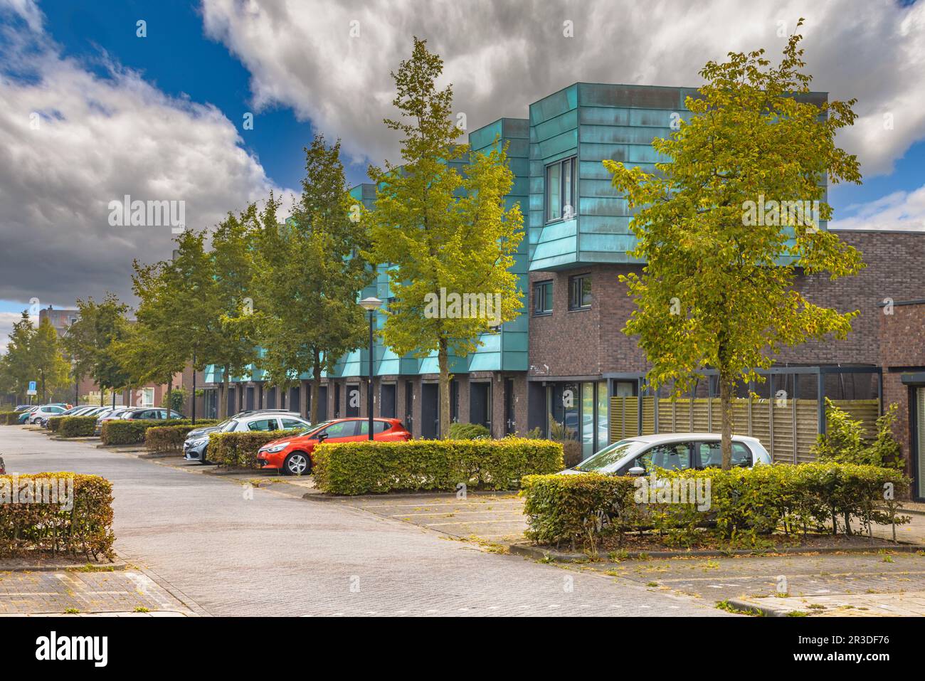 Eine Reihe moderner Häuser in einer natürlichen grünen Straße. Modernes Viertel mit Gärten und privaten Parkplätzen. Blick auf die Straße in Heerhugowaard, Nether Stockfoto