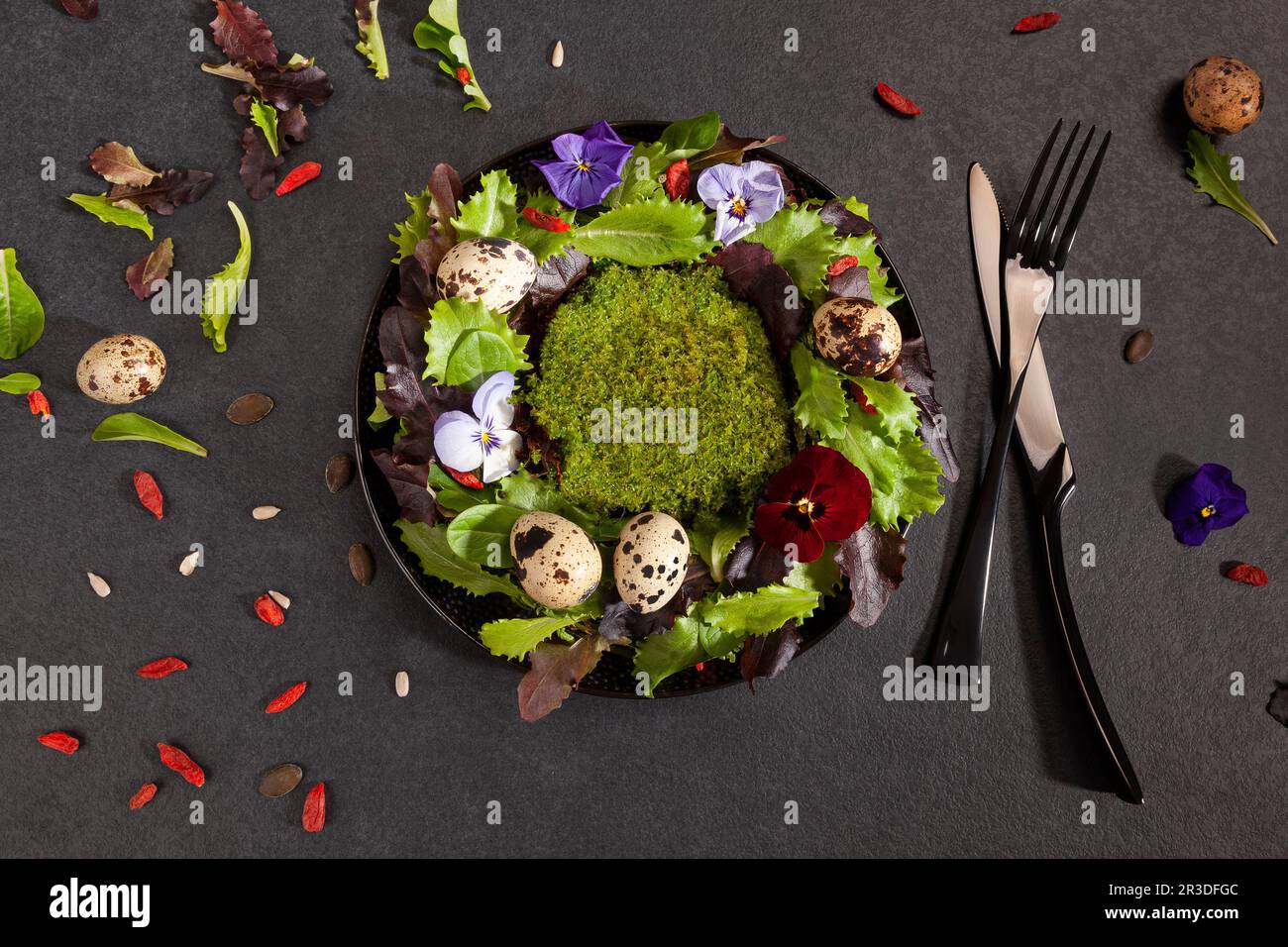 Kranz aus Salatblättern, Blumen und Eiern von oben. Stockfoto
