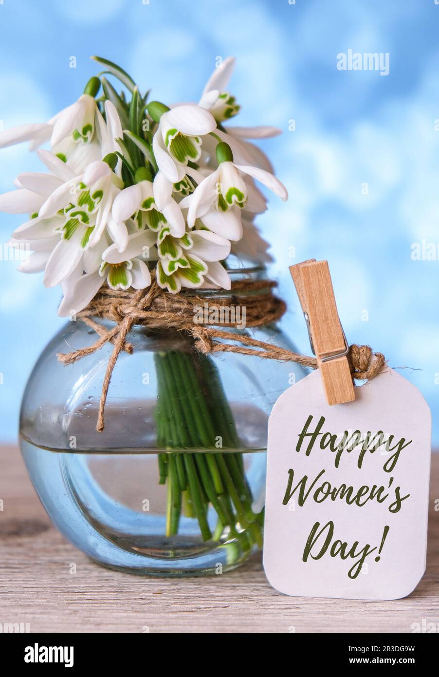 Grußkarte mit Schriftzug „Happy Womens Day“. Frühlingsblumen Schneeglöß. Schöner zarter Blumenstrauß. Urlaubskonzept Stockfoto
