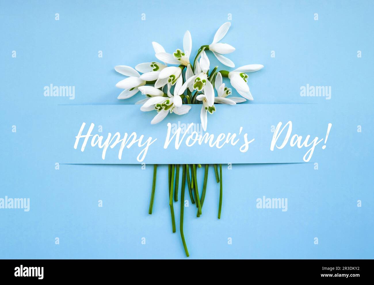 Grußkarte mit Schriftzug „Happy Womens Day“. Frühlingsblumen Schneeglöß. Schöner zarter Blumenstrauß. Urlaubskonzept Stockfoto