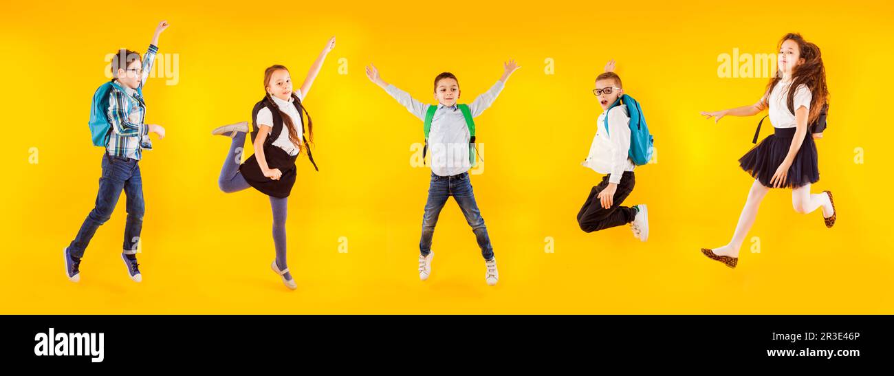 Die verschiedenen Schulkinder hüpfen und winken mit den Händen Stockfoto