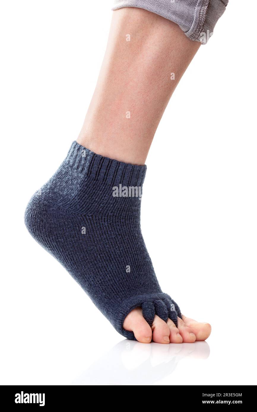 Füße mit Yoga-Zehentrennsocken auf weißem Hintergrund. Stockfoto