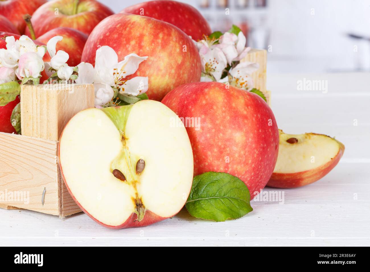 Äpfel Früchte rote Apfelfrucht Box auf Holzbrett mit Blumen und Blättern Stockfoto