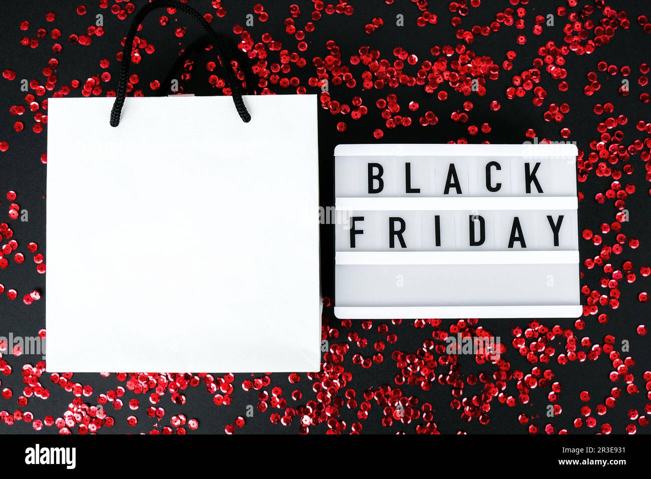 Lightbox mit schwarzem Text AM FREITAG auf dunklem Hintergrund mit Einkaufstaschen aus Papier, Verkaufskonzept. Vorlage Black friday Angebot m Stockfoto