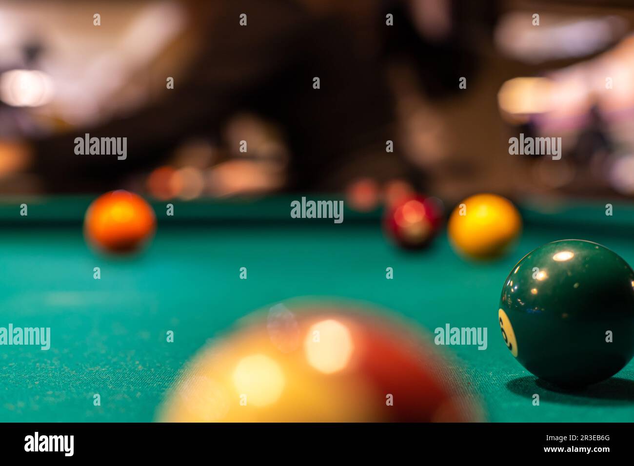Bild des Poolkonzepts (Einsatzsport, Billard). Bälle auf einem Billardtisch in einer Billardhalle. Stockfoto