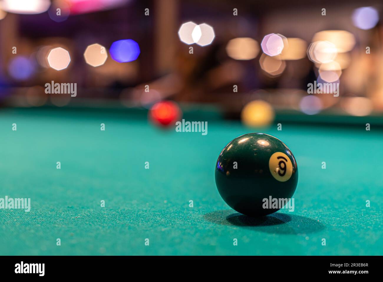 Bild des Poolkonzepts (Einsatzsport, Billard). Bälle auf einem Billardtisch in einer Billardhalle. Stockfoto
