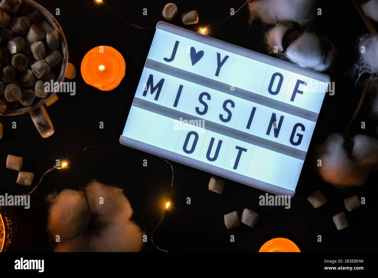 Lightbox mit Text JOMO Joy of Missing Out. Entspannungsbegriff aus Information und Gadgets. Draufsicht. Flach verlegt. Tasse mit Stockfoto