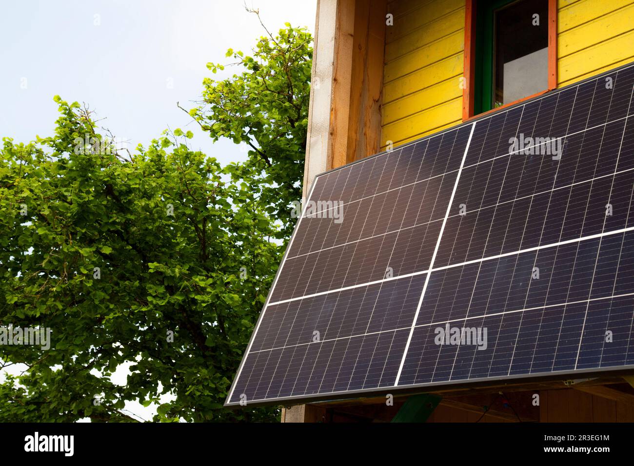 Modernes Haus mit blauen Solarpaneelen auf dem Dach - nachhaltige Energie Stockfoto