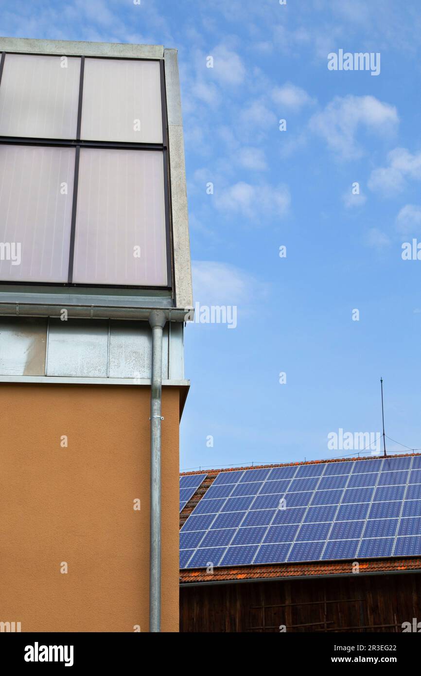 Modernes Haus mit blauen Solarpaneelen auf dem Dach - nachhaltige Energie Stockfoto