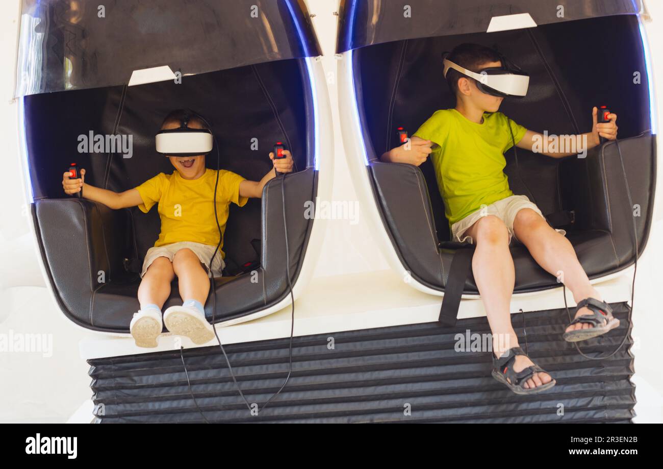 Die kleinen Jungen spielen das Spiel in Virtual-Reality-Brillen im Freien Stockfoto