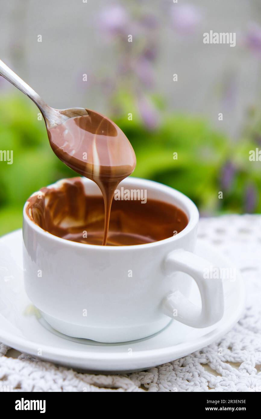 Heiße Schokoladenbecher auf dem Tisch im Café im Sommer. Kaffee und Frühstück im Restaurant. Schokolade, heiße Milchschaum, Kakao. Stockfoto