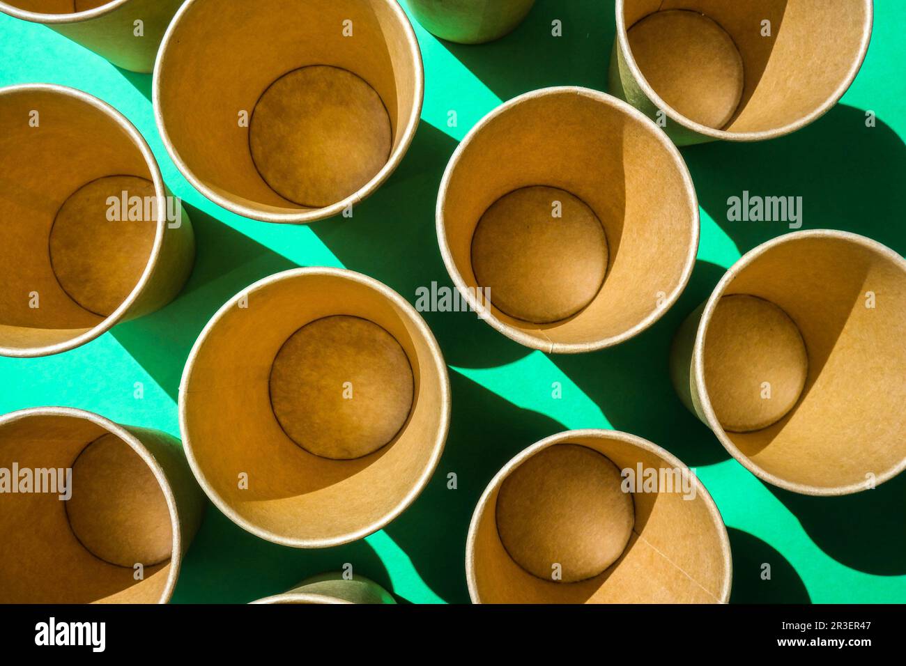 Leere recycelbare Pappbecher auf grünem Hintergrund. Viele Take-away-Becher zum Trinken. Umweltfreundlich. Zero Waste Kunststofffreies Konzept. Stockfoto