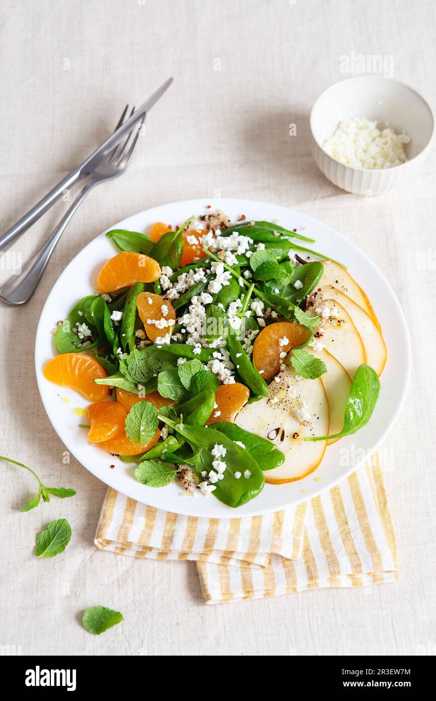 Spinat und Quinoa Salat mit Birnen, Orangen und Ricotta. Gesunde Mahlzeit Vorbereitung. Pflanzliche Gerichte. Grün leben. Veganes Rezept. Foo Stockfoto
