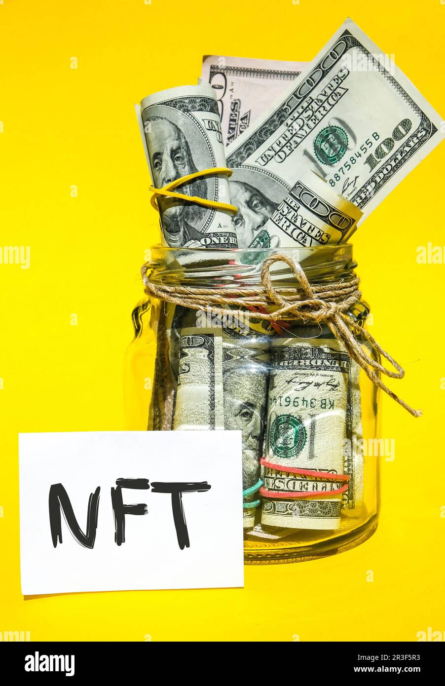 Nicht fungibler NFT-Tokentext. Nicht fungibler Token für Konzeptwörter NFT auf Papier. Hintergrund der Dollarscheine. Blockkette Anlage c Stockfoto