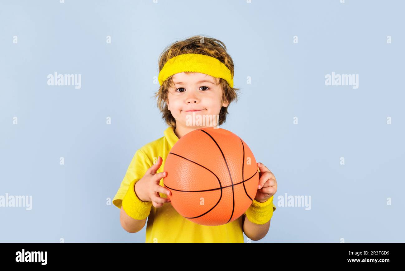 Sportsmann Kind mit Basketballball. Sportausrüstung. Süßer Junge, der Basketball spielt. Profisport. Kleiner Basketballer mit Basketball. Sport Stockfoto