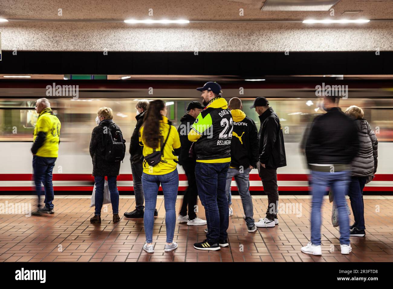 Bild der Gruppe von BVB Borussia Dortmun-Anhängern, die an einer U-Bahn-Station der dortmunder stadtbahn im Stadtzentrum auf einen Zug warten Stockfoto