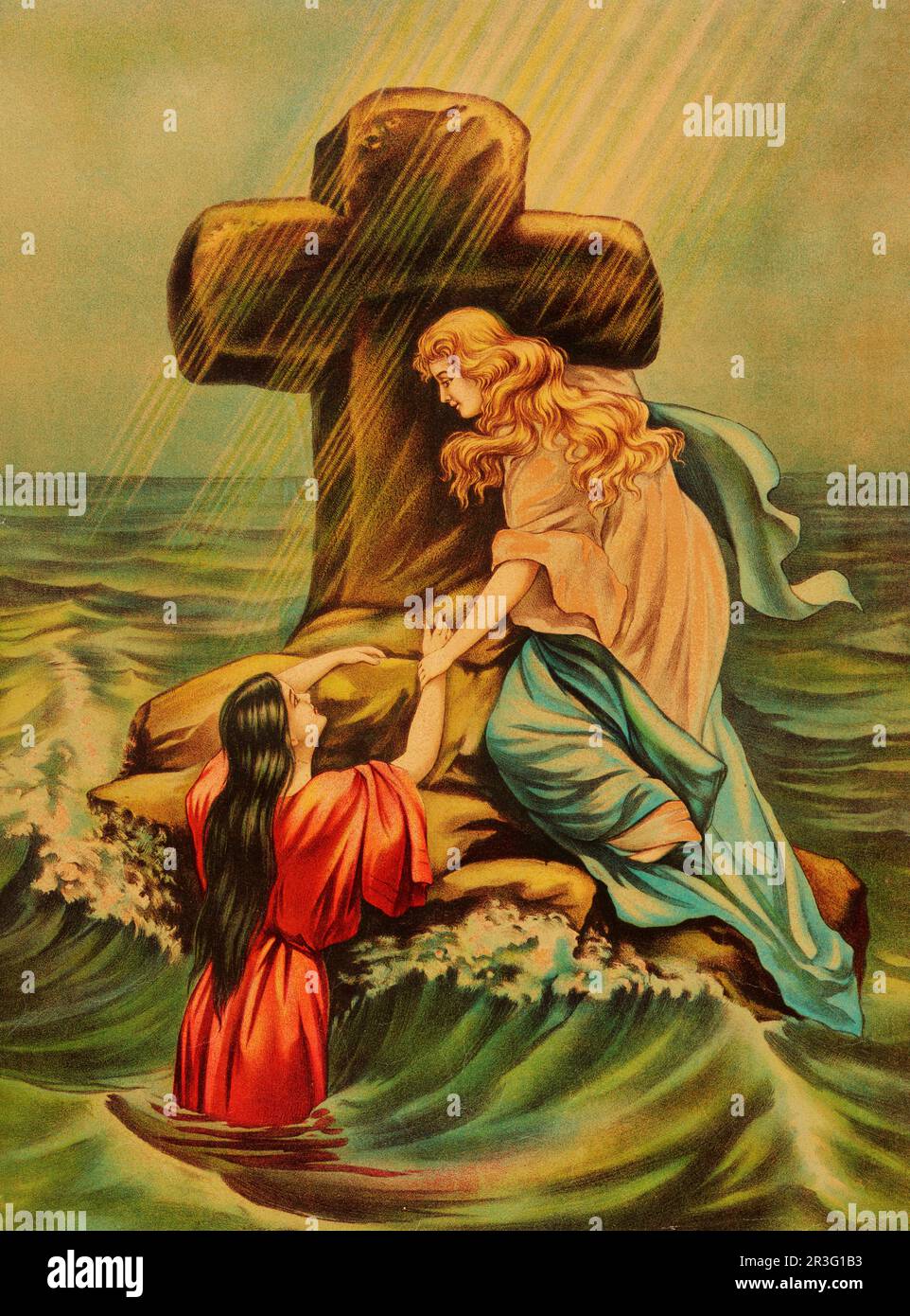 Ein Paar Frauen auf einem Felsen mit einem religiösen Kreuz im Ozean. Stockfoto