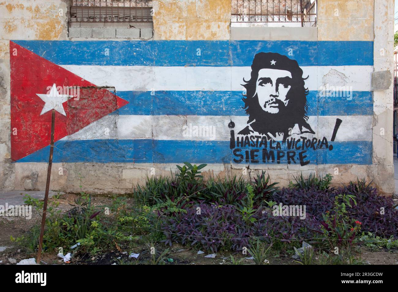 Nachbarschaft in der Altstadt von Havanna mit handgemalten Wandgemälden, die die kubanische Flagge und Che Guevara zeigen. Stockfoto